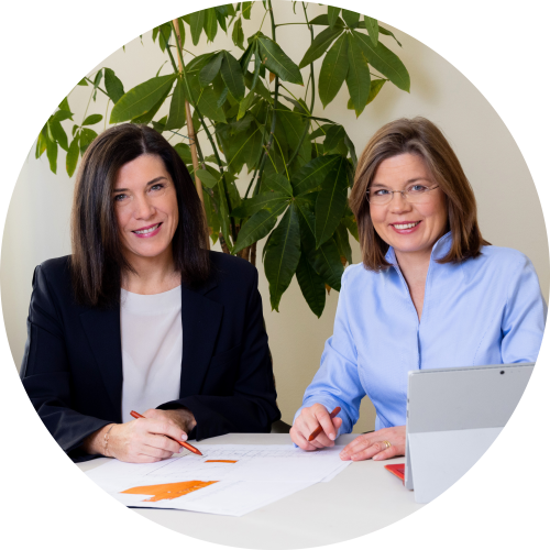 Claudia Descovich und Gerda Ehrlich-Ratzinger sitzen am Schreibtisch in ihrem Büro